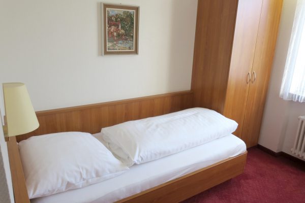 Single Room with Nightstand Lamp and Carpeted Floor – Hotel Find Stuttgart