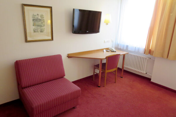 Zimmer mit Doppelbett und gemütlicher Sitzecke – zentral in Stuttgart