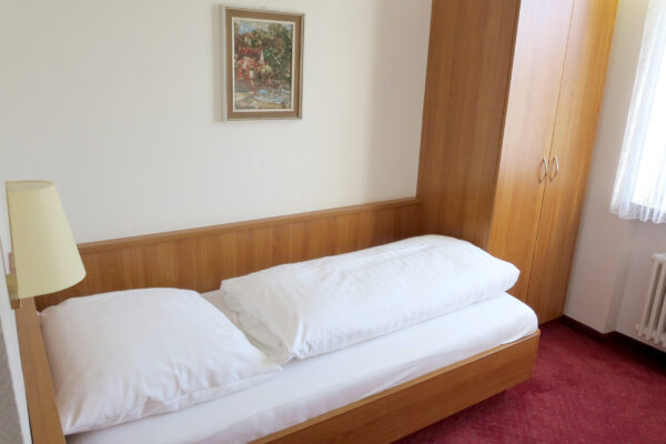 Einzelzimmer mit Nachttischlampe und Teppichboden – Hotel Find Stuttgart